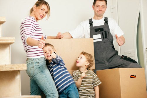 Professional movers carrying furniture through a residential street in Kingston